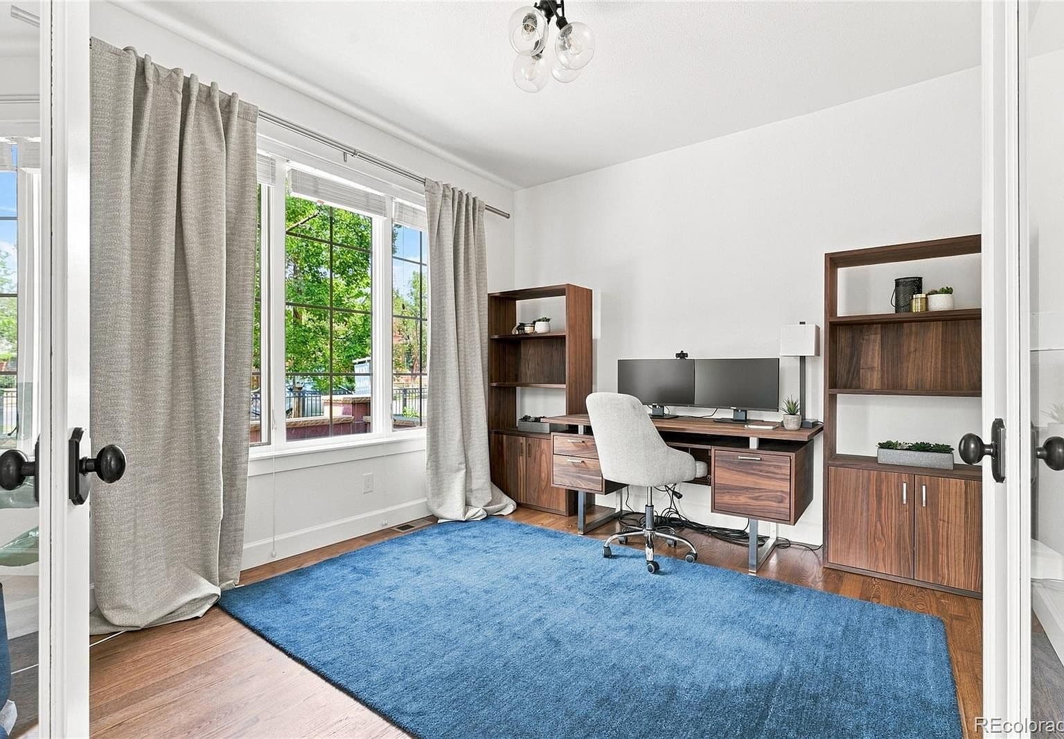 Bright home office with built-ins and oversized windows.