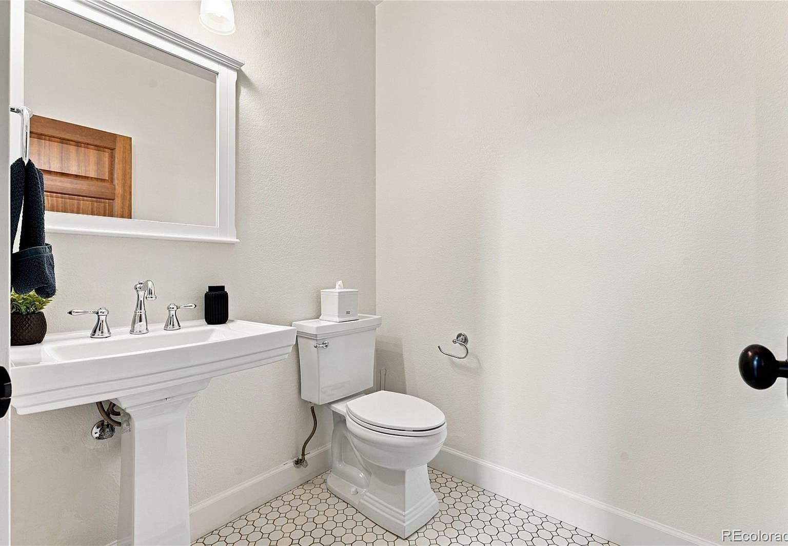 Stylish powder bath with hex tile flooring.