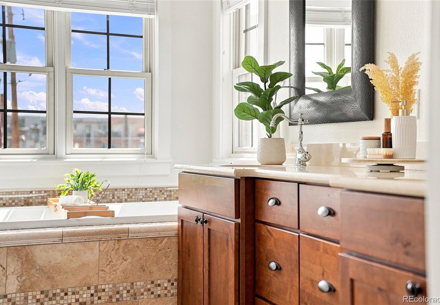 Sun-filled vanity overlooks relaxing soaking tub nook.