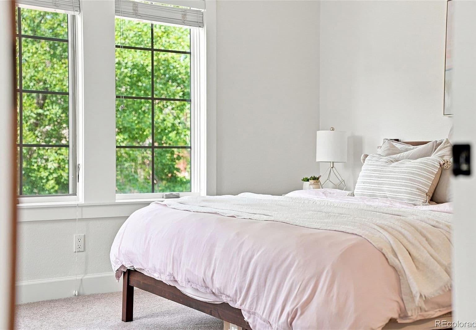 Cozy bedroom retreat with tranquil treetop views.