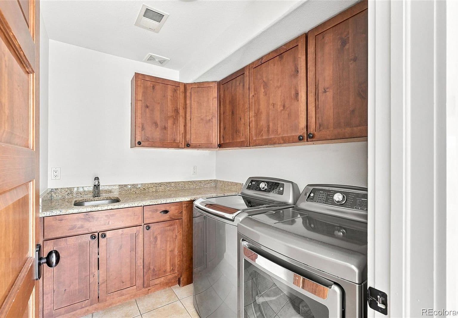 Well-appointed laundry with sink and abundant cabinetry.