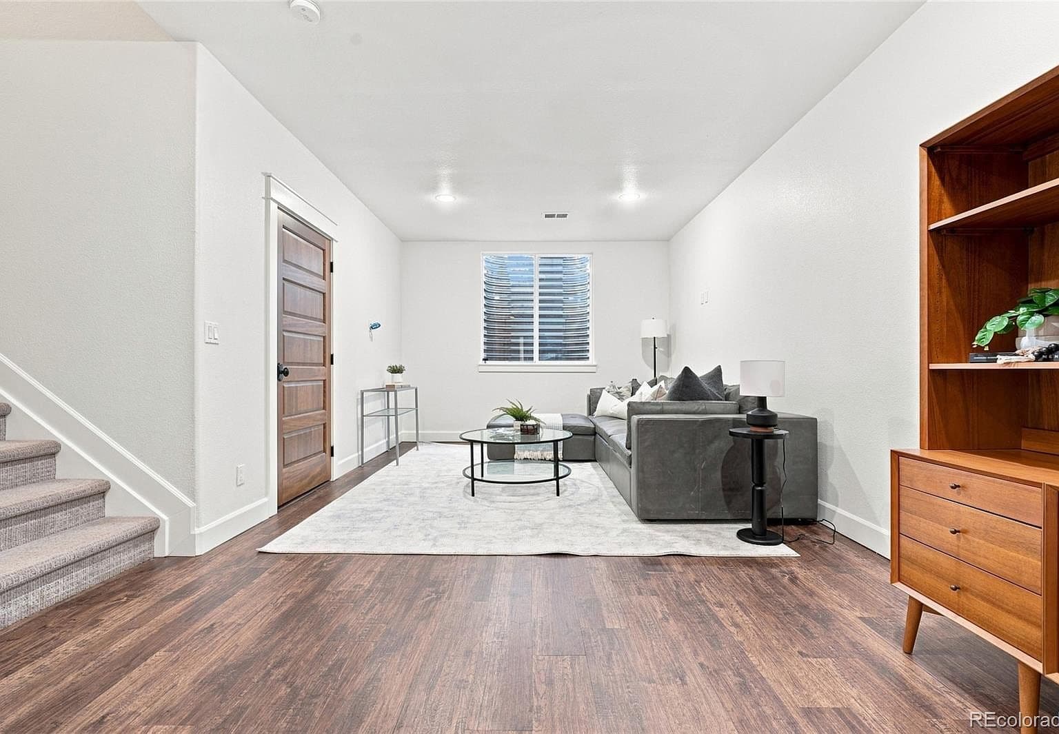 Finished basement family room with wide-plank floors.