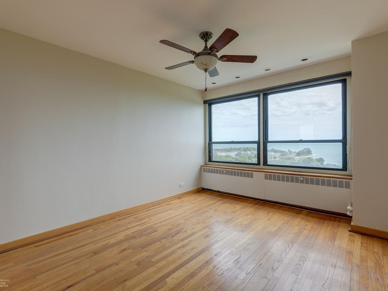 Bright bedroom features hardwood floors and an east-facing lake view.