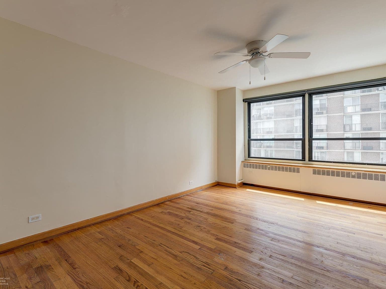 Spacious bedroom offers hardwood floors and wide windows.