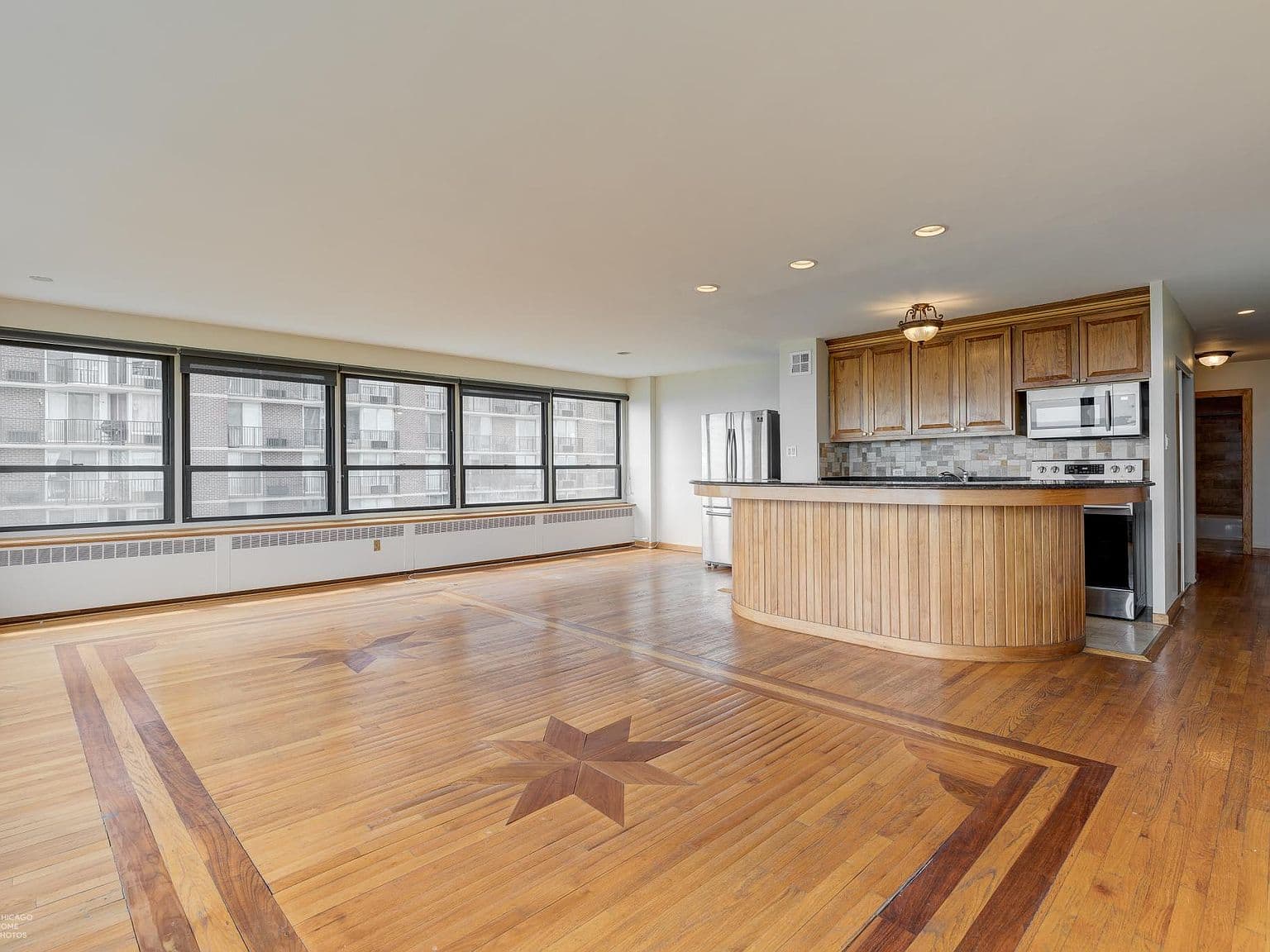 Open kitchen overlooks generous living space with distinctive hardwood inlay.