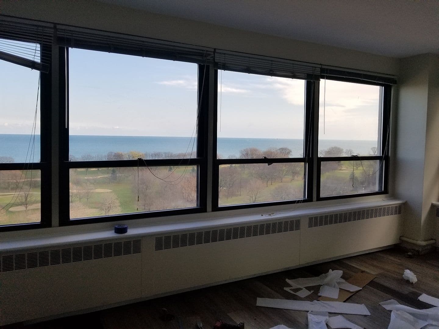 Expansive windows bring lake views into this hardwood-floored room.