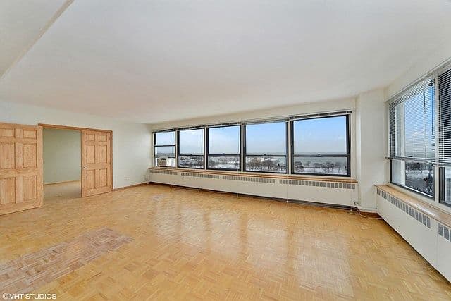 Expansive living room with hardwood floors and lake views