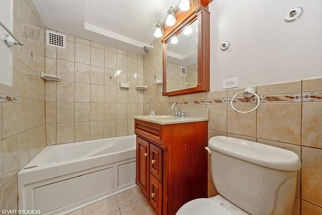 Tiled bathroom with a soaking tub and wood vanity