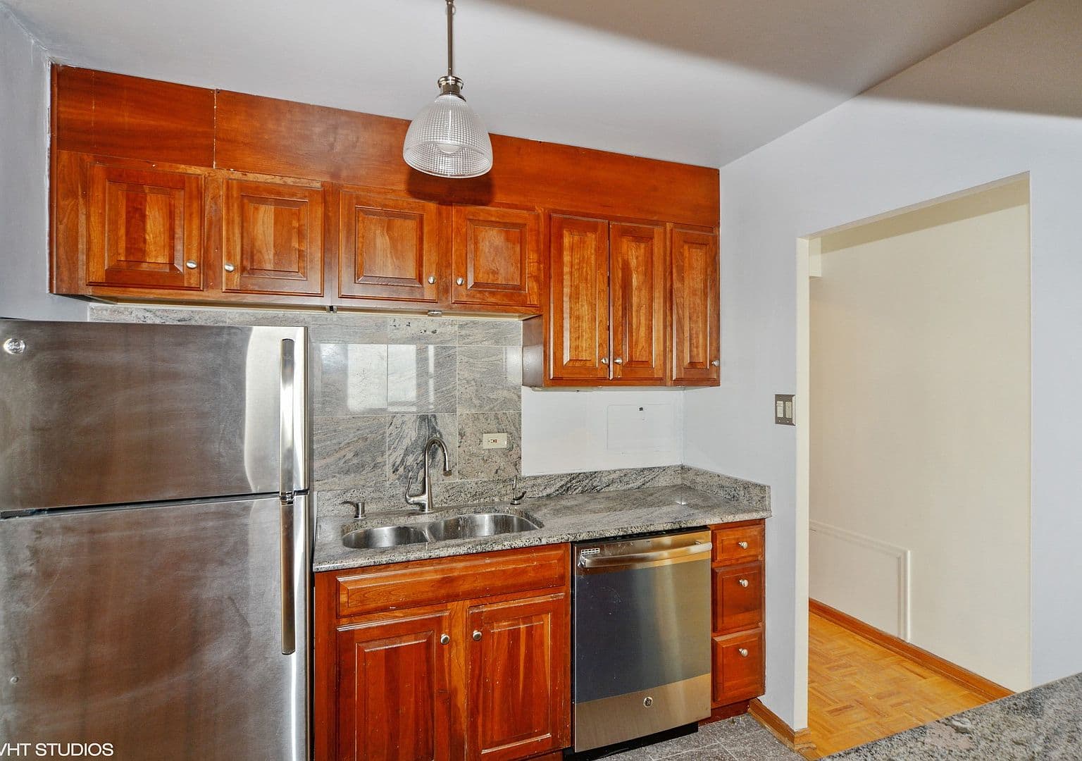 Warm wood cabinetry and stainless appliances anchor the kitchen.