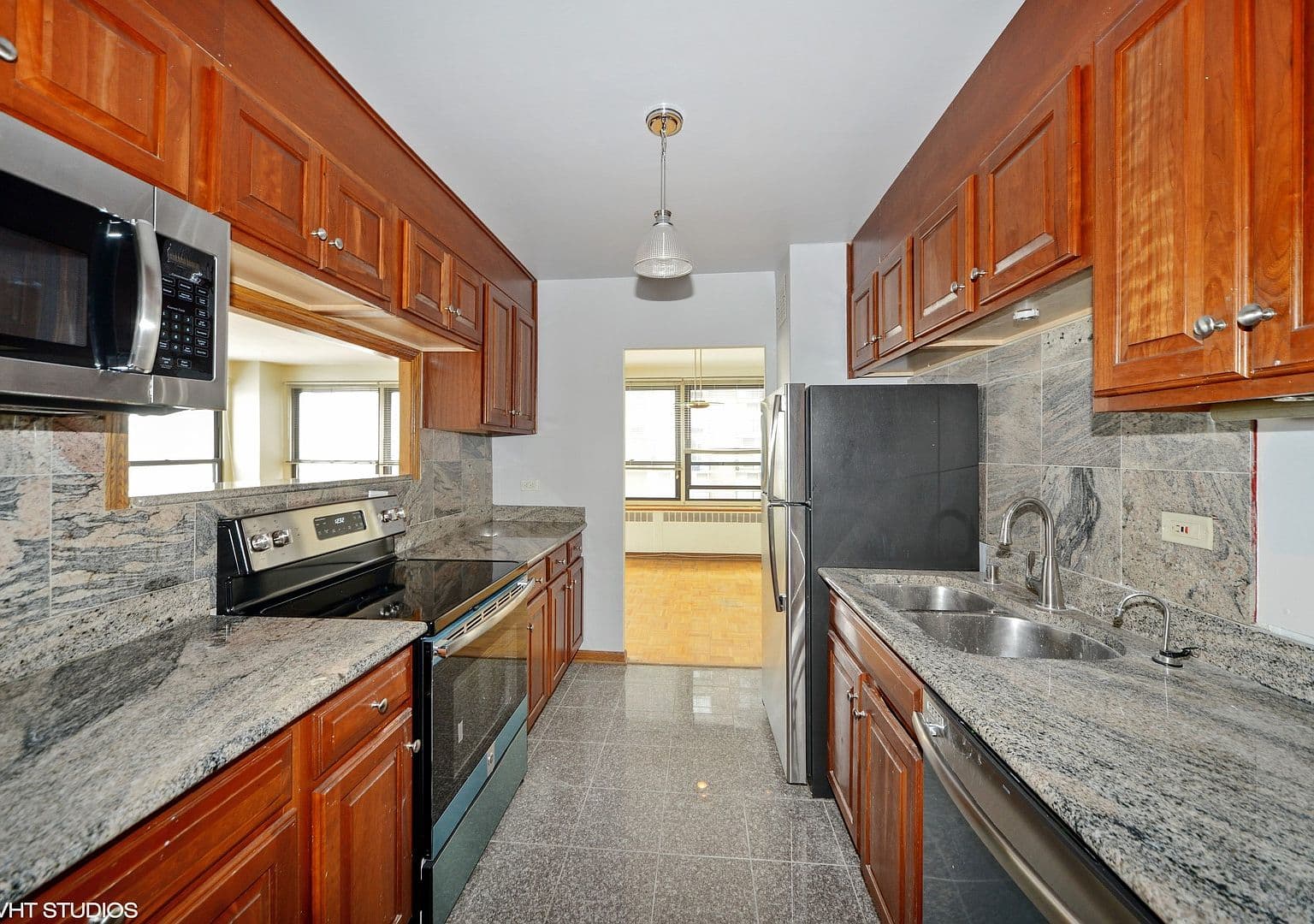 Granite counters and a pass-through connect kitchen and living space.