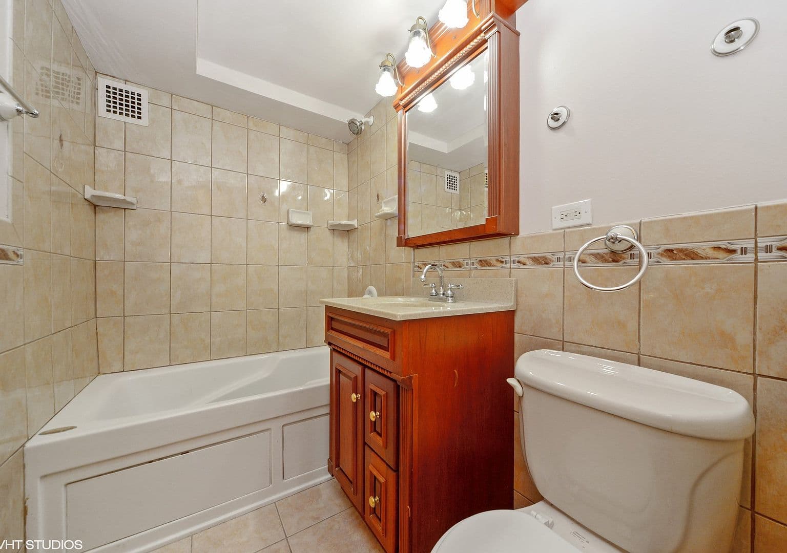 Second full bathroom includes a tub and tiled surround.