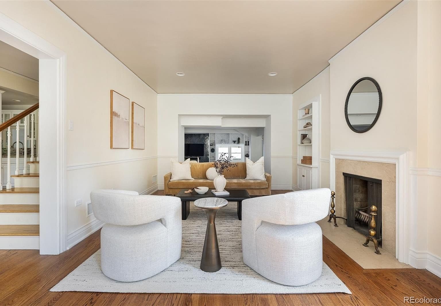 Sunlit living room with fireplace and sheer drapes