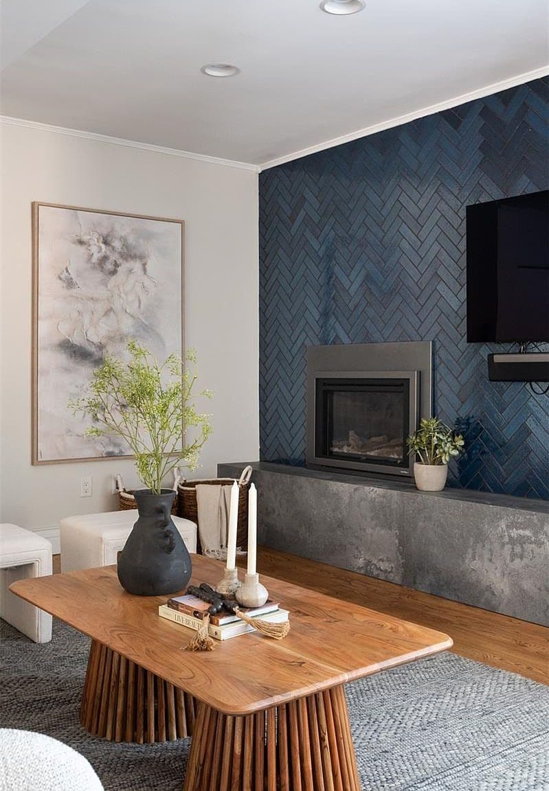 Wood coffee table beneath navy tile fireplace wall