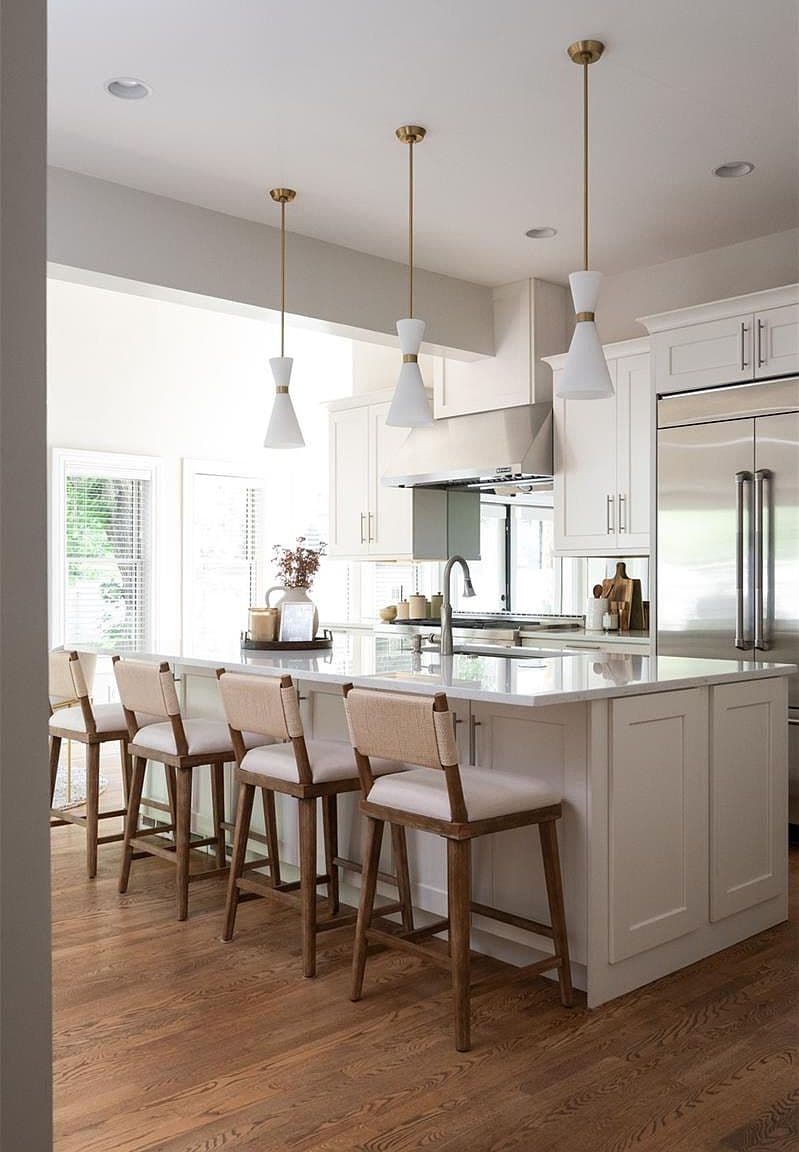 Kitchen island with woven counter stools and pendant lights