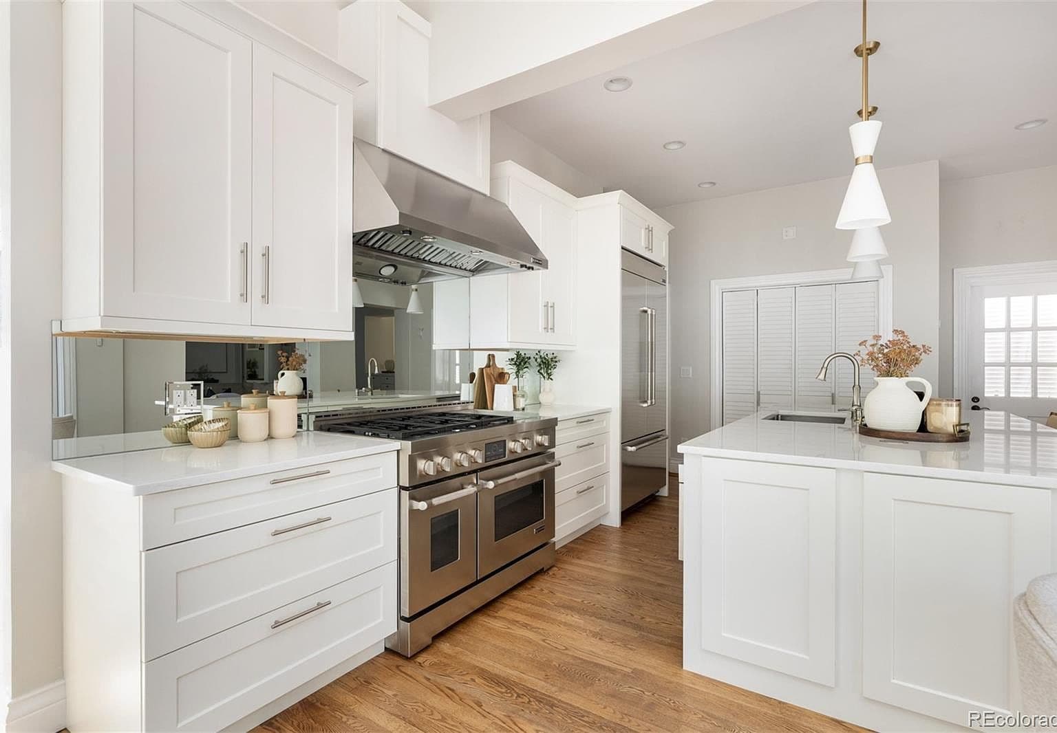 Professional gas range with mirrored backsplash and custom hood