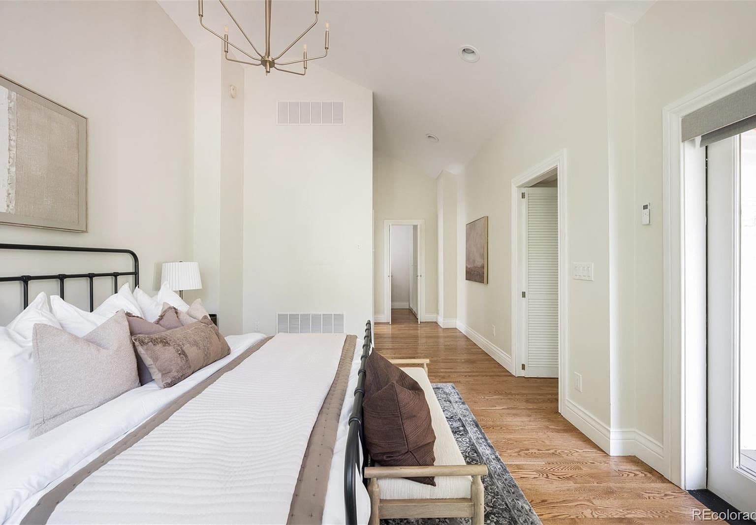 Vaulted primary suite hallway with king bed