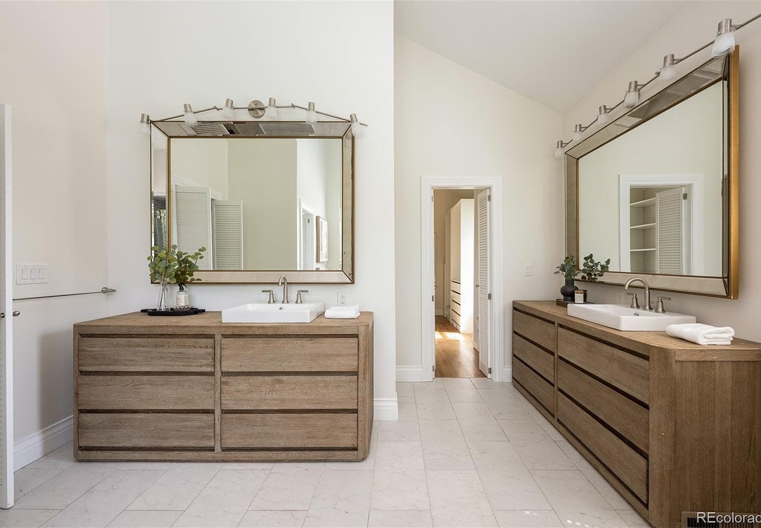 Dual oak vanities with beveled mirrors in primary bath