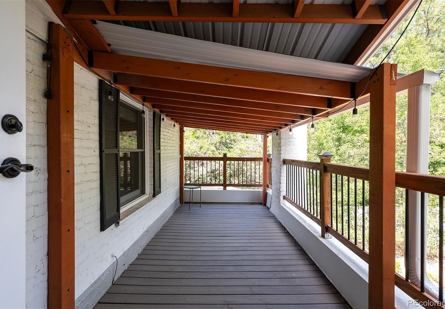 Covered balcony with timber beams and string lights