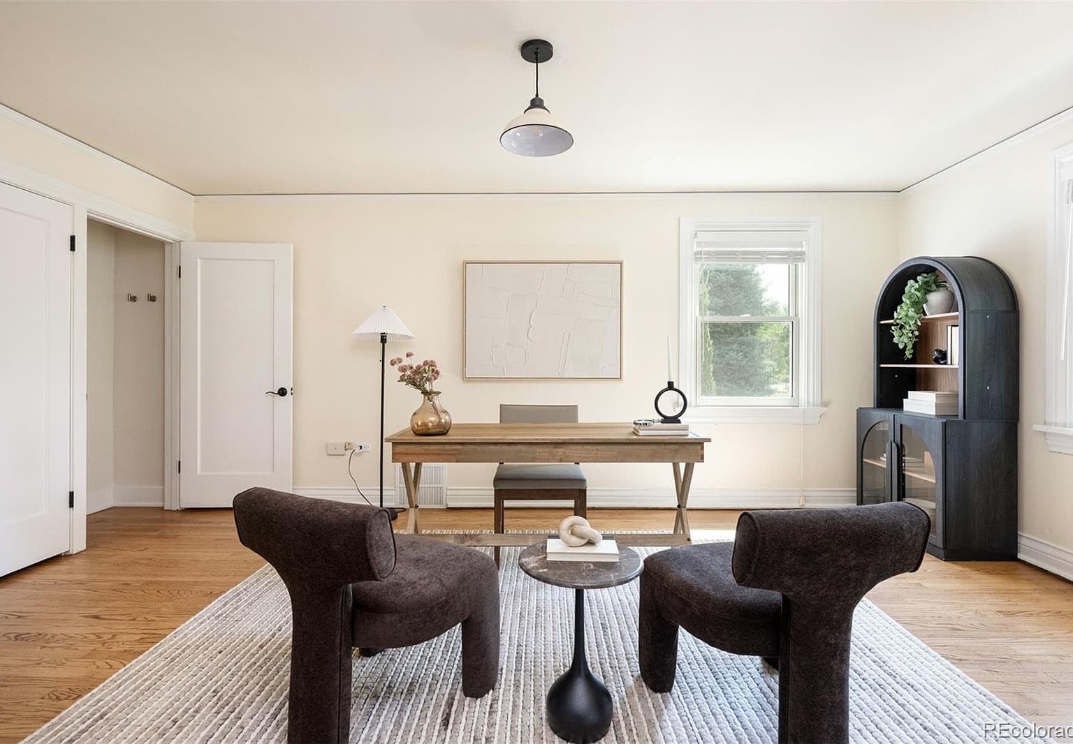 Home office with writing desk and arched bookcase