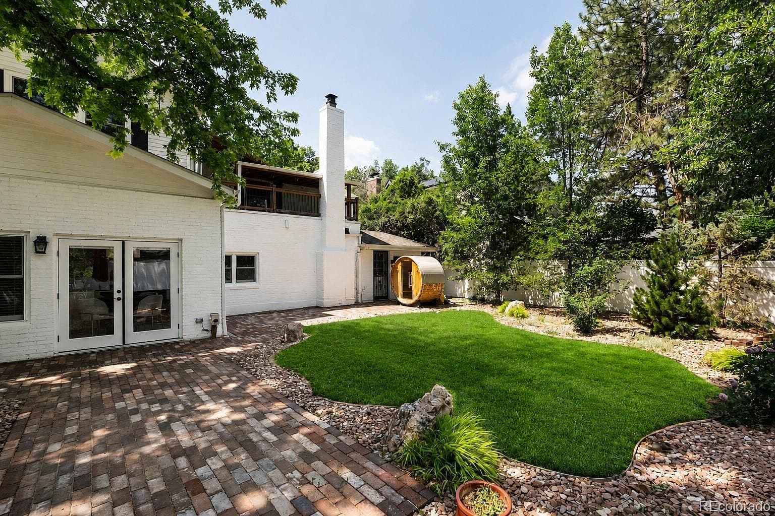 Backyard lawn, paver patio, and barrel sauna
