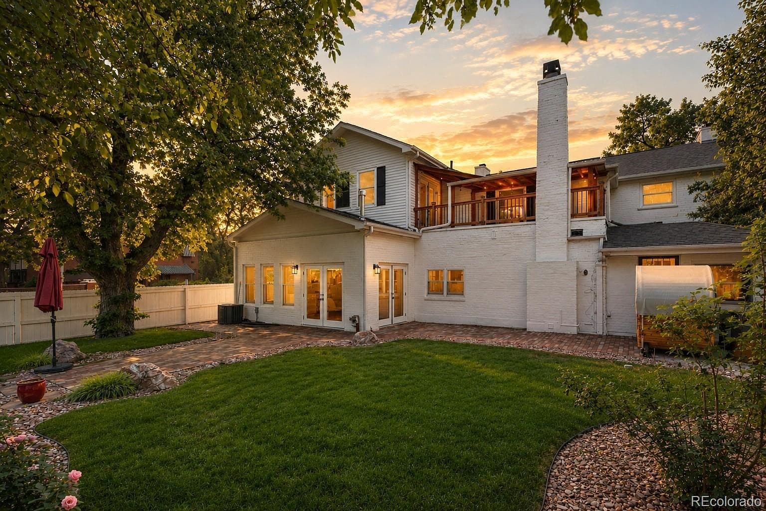Sunset over backyard lawn and covered upper balcony