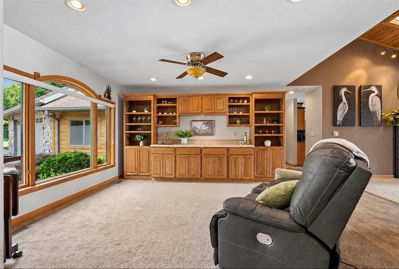 Sunlit lounge with custom wet bar and display shelving.