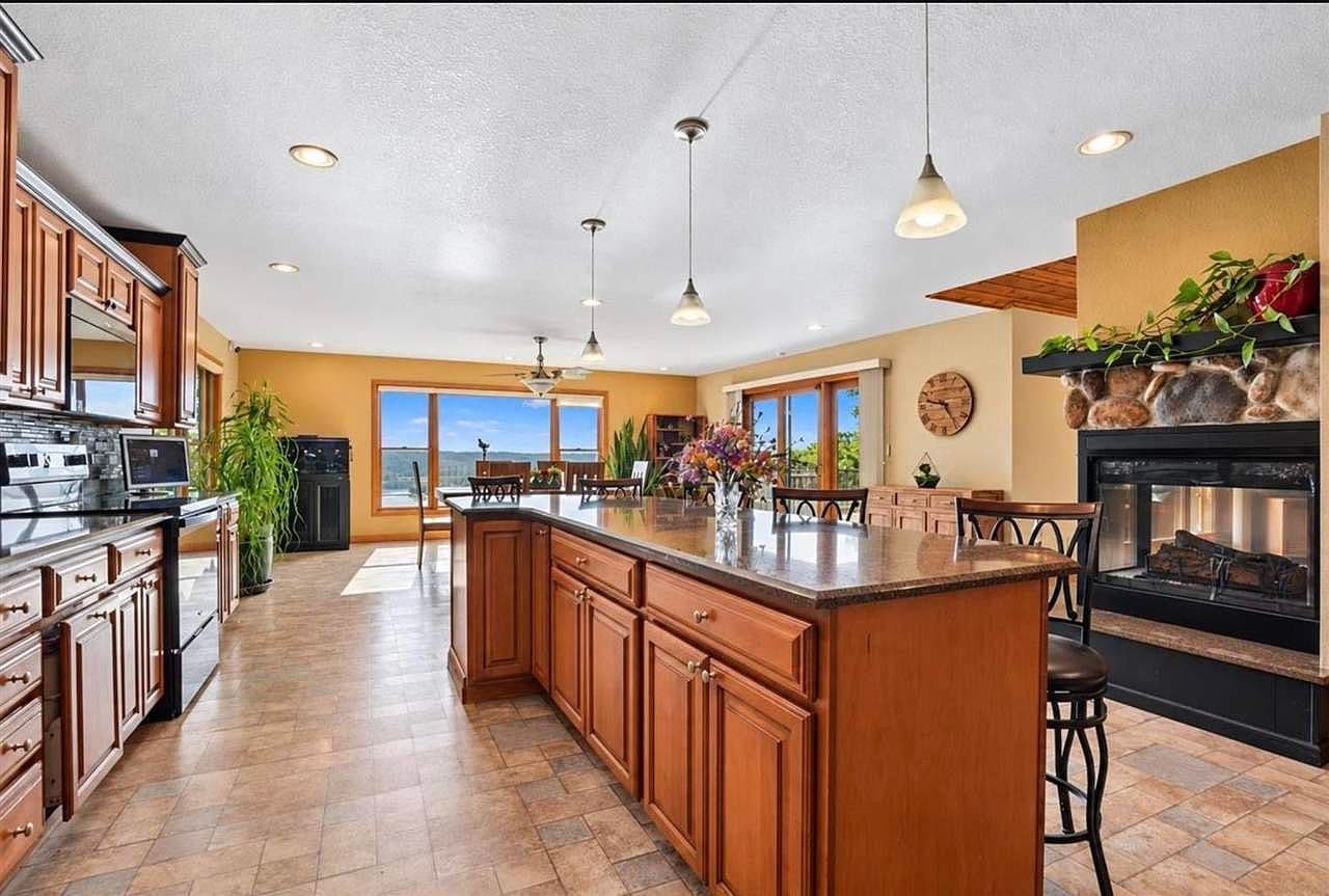 Chef’s island kitchen with river views and fireplace ambiance.