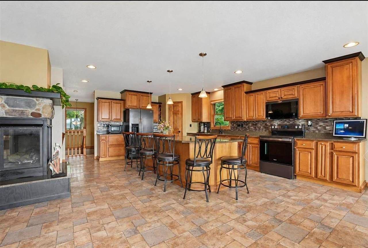 Entertain with oversized island, rich cabinetry, and tile floors.
