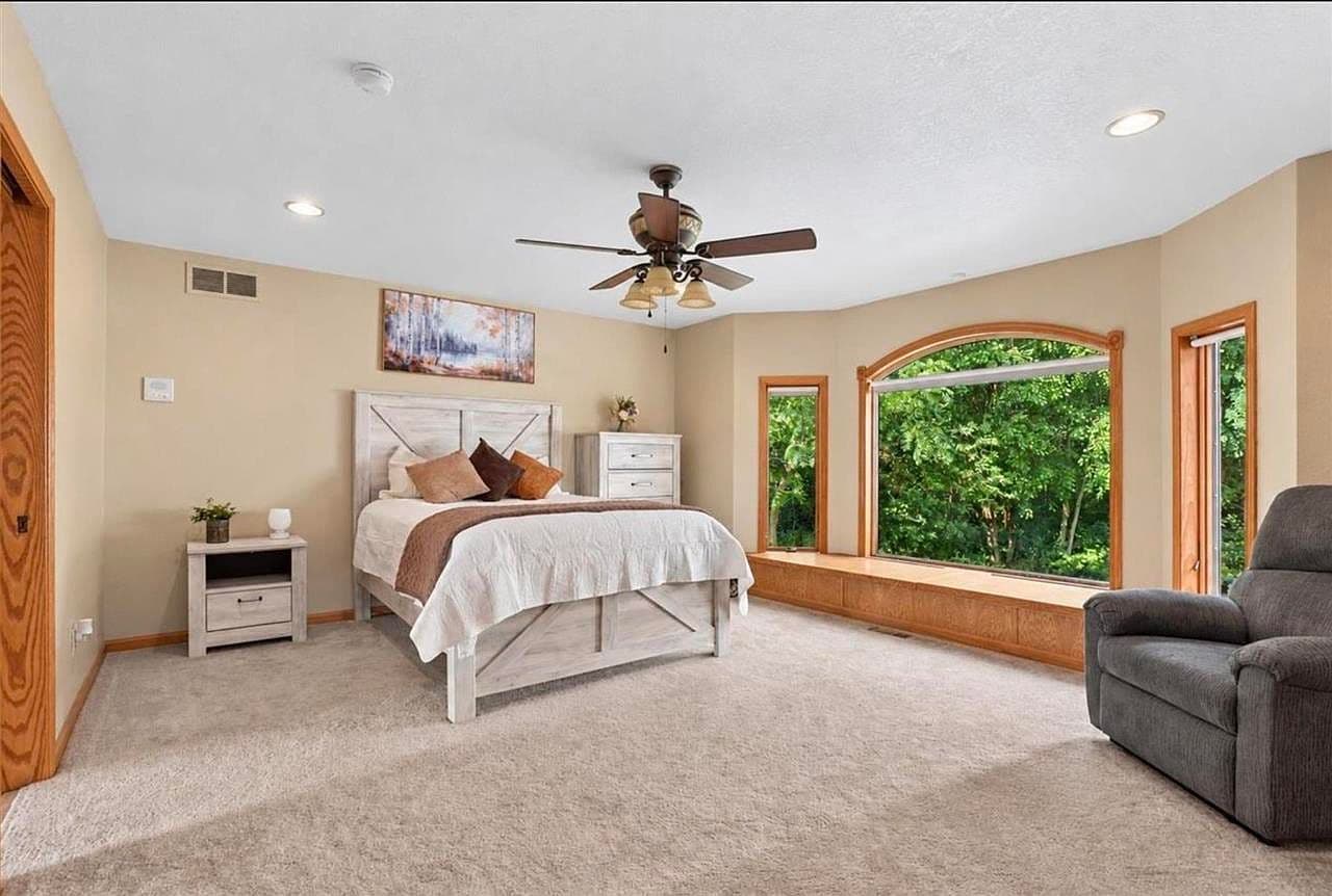 Serene main-floor bedroom with oversized picture window views.