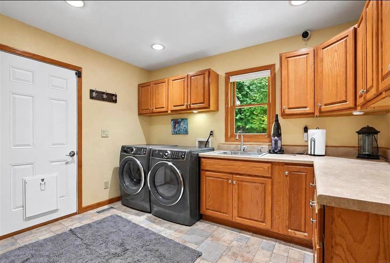 Spacious main-level laundry with sink and ample cabinetry.