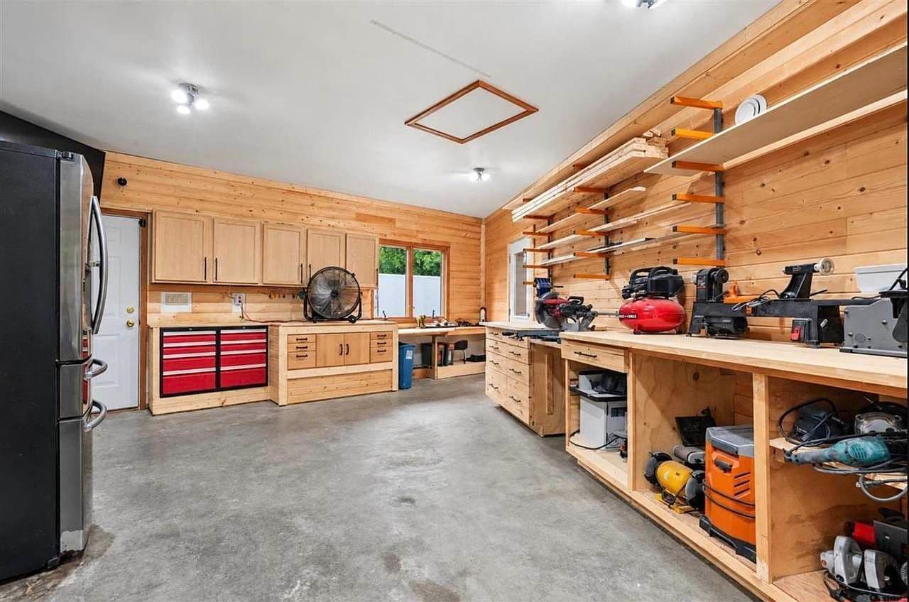 Spacious hobby garage with custom storage and workbenches.
