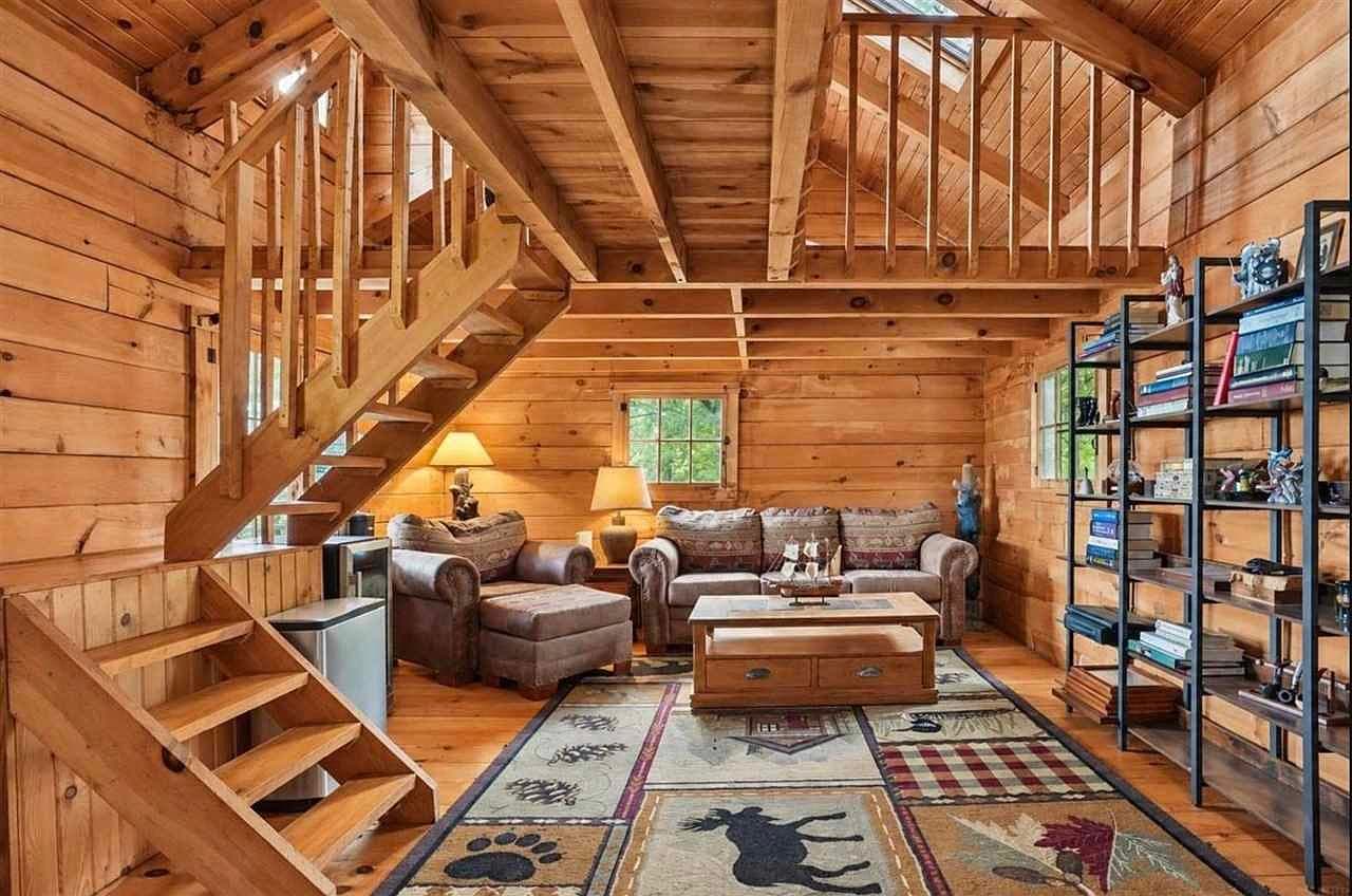 Cozy Amish-built cabin living space with loft stairs.