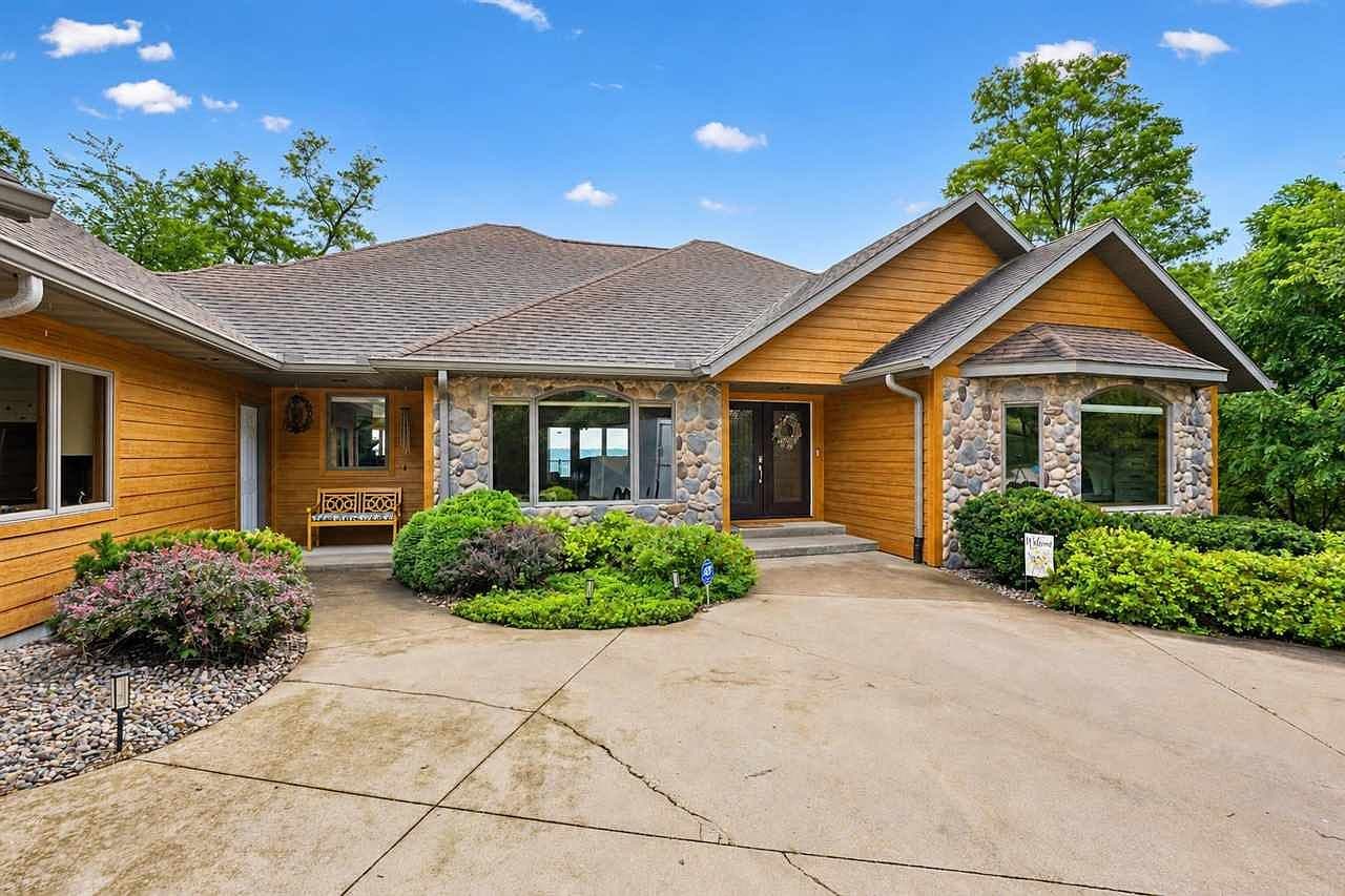 Welcoming stone-and-cedar entry with manicured landscaping.